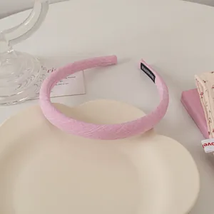 Detail of pink fabric headband with handmade label on cream heart-shaped tray
