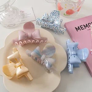 Détail de pinces à cheveux à nœuds pastels de style français sur un plateau fleuri