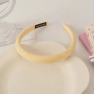 Detail of light yellow fabric headband with handmade label on cloud tray