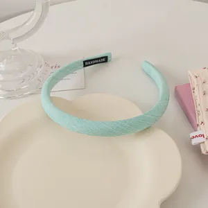 Detailed fabric texture of mint green handmade headband with fine white weaving