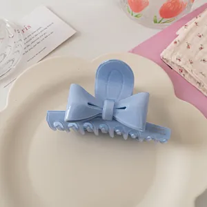 Vue détaillée de la pince à cheveux noeud en acétate bleu clair avec paillettes dorées