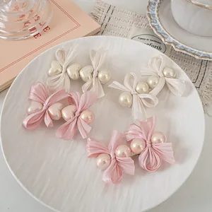 Detail view of pink and cream organza bow hair clips with lustrous faux pearls