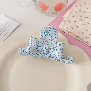 Détail d'une pince à cheveux avec motif marbré bleu et marquage France doré fait main