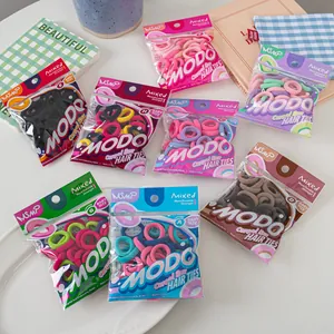 Detail view of colorful baby elastic hair ties in transparent zipper bags with MODO branding