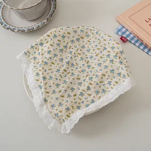 Detailaufnahme von Blumen-Bandana mit weißem Spitzenbesatz in gemütlicher Kulisse