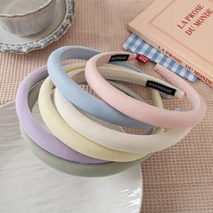 Macro detail of macaron pastel padded headbands with handmade cloth label and fabric texture