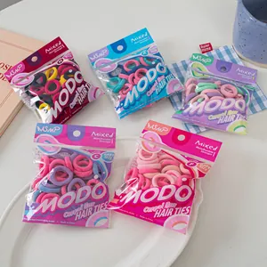 Detailed view of colorful baby hair ties in cereal box style packaging on a table