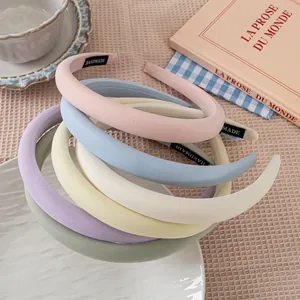 Close-up of five colorful macaron padded headbands with handmade labels on a tray