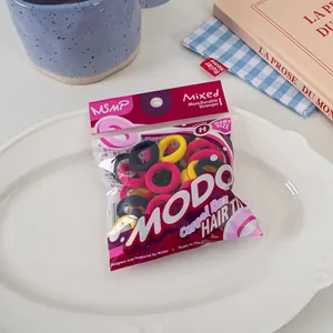 Detail of candy-colored elastic hair ties in baby size on a white ceramic plate