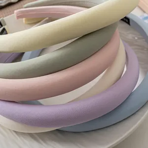 Thick macaron sponge headbands in pastel fabric stacked neatly on a white tray