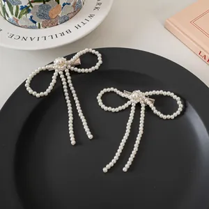 Französischer Perlen-Haarclip mit Schleife und Quasten auf einem schwarzen Tablett