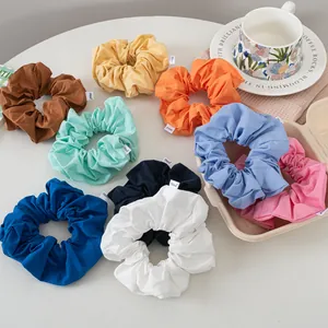 Colorful cotton scrunchies set in various pastel shades with minimalist woven labels