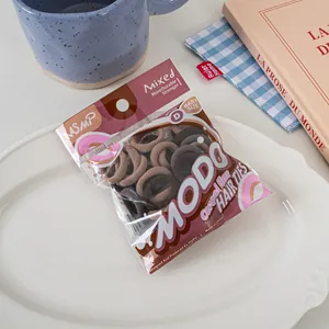 Macro shot of candy-colored elastic hair ties in brown tones on a white ceramic plate