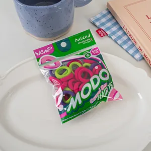 Detail of colorful baby size elastic hair ties in MODO cereal box packaging