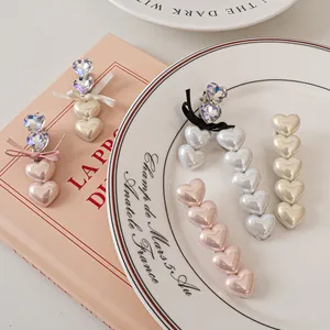 Dettaglio di fermagli per capelli a cuore perlato e fiocchi di strass su libro vintage