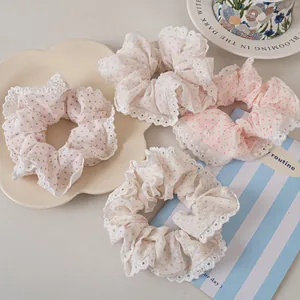 Close-up of four lace polka dot scrunchies in pastel colors on decorative tray