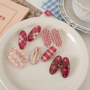 Vintage red plaid hair clip set with 9 pieces of sweet oval duckbill clips on a plate