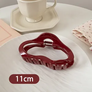 Detailansicht der 11 cm dunkelroten gewellten Haarklammer auf Lifestyle-Hintergrund