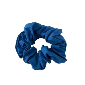 Deep blue cotton fabric scrunchie with soft pleated texture on white background