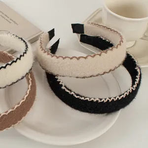 Détail de serre-têtes en laine avec coutures contrastées ondulées aux tons café d'automne