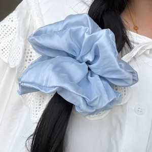 Oversized light blue satin scrunchie shown on a ponytail with a silky finish