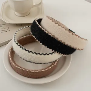 Détail de bandeaux en maille pelucheuse à bords ondulés aux tons café et crème