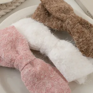 Makro-Detail von drei flauschigen Schleifen-Haarspangen aus Mohair in Rosa Weiß und Braun