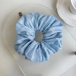 Close-up of oversized light blue scrunchie with soft pleated chiffon fabric texture