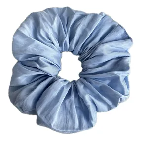 Oversized light blue scrunchie with pleated silk texture for voluminous high ponytail