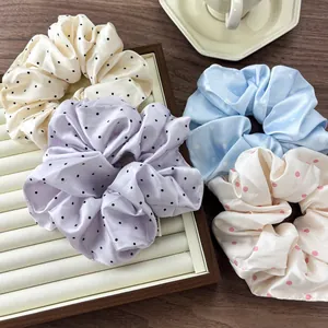 Satin polka dot hair scrunchies set in lavender, cream, and blue with silky texture