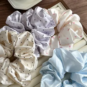 French style satin polka dot scrunchies in four pastel colors on a wooden tray