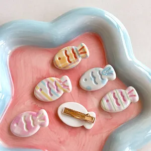 Cute macaron color fish-shaped hair clips in various patterns on a ceramic tray