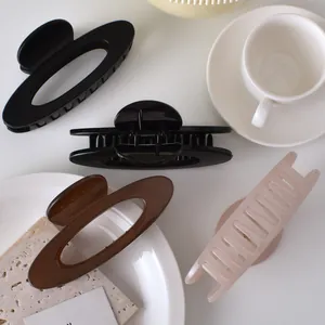 Flat lay of minimalist oval and rectangular hair claws in various colors and finishes