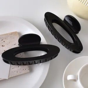 Minimalist oval hollow hair claw set in matte and glossy black finish for elegant hairstyling