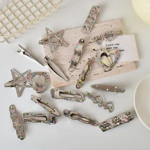 Detailed flat lay of silver Y2K metal hairpins with colorful dots in various geometric shapes