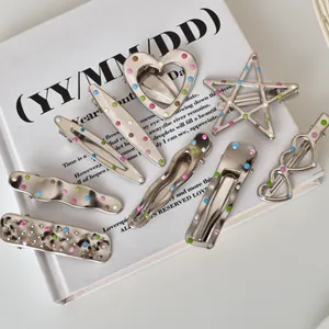 Detailed close-up of Y2K silver metal hair clips with colorful polka dots on a book cover