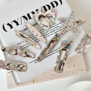 Macro view of silver metal hair clips with colorful polka dots in various geometric shapes