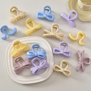 Gros plan de pinces à cheveux pastel et nœuds sur une assiette blanche en céramique