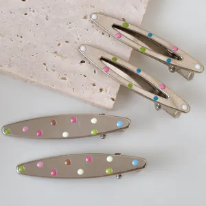 Silver metal Y2K hair clips with colorful enamel polka dots in triangular and oval shapes