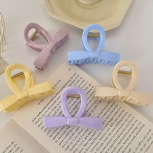 Détail de cinq pinces à cheveux nœuds colorées aux tons pastel sur un plateau