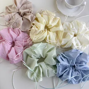 Set of six colorful satin bow scrunchies in pastel tones on a white background