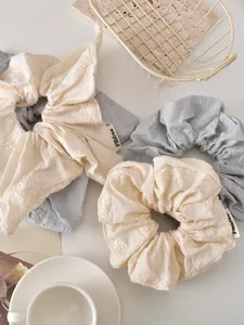 Detail of floral embroidery on vintage scrunchies and bow hair ties for women