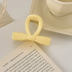 Détail d'une pince à cheveux nœud jaune crème avec ressort en métal doré