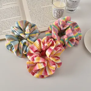 Detailed view of colorful striped scrunchies on a textured background with cozy props