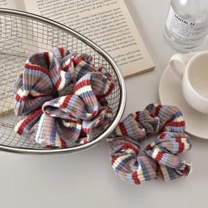 Close-up of blue and red striped fabric scrunchies with a soft knit texture