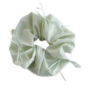 Mint green satin scrunchie with silk ribbon bows for elegant French ballet style hairstyle