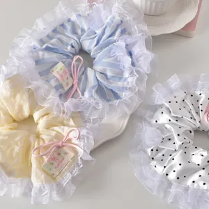 Détail de trois chouchous en dentelle avec nœuds roses et étiquettes faites à la main