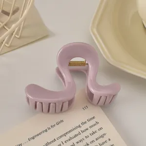 Détail de la pince à cheveux lilas montrant le fini brillant et le ressort métallique