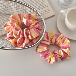 Detailed close-up of ribbed texture and woven label on sweet striped scrunchie set