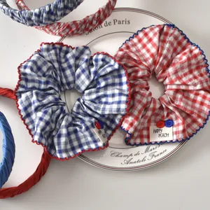 Detalle de coletero y diadema de cuadros rojos y azules con bordes ondulados y botón